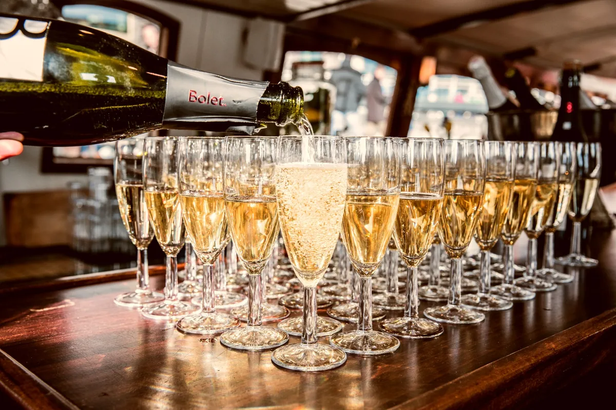 Champagne wordt ingeschonken in glazen aan boord van een salonboot
